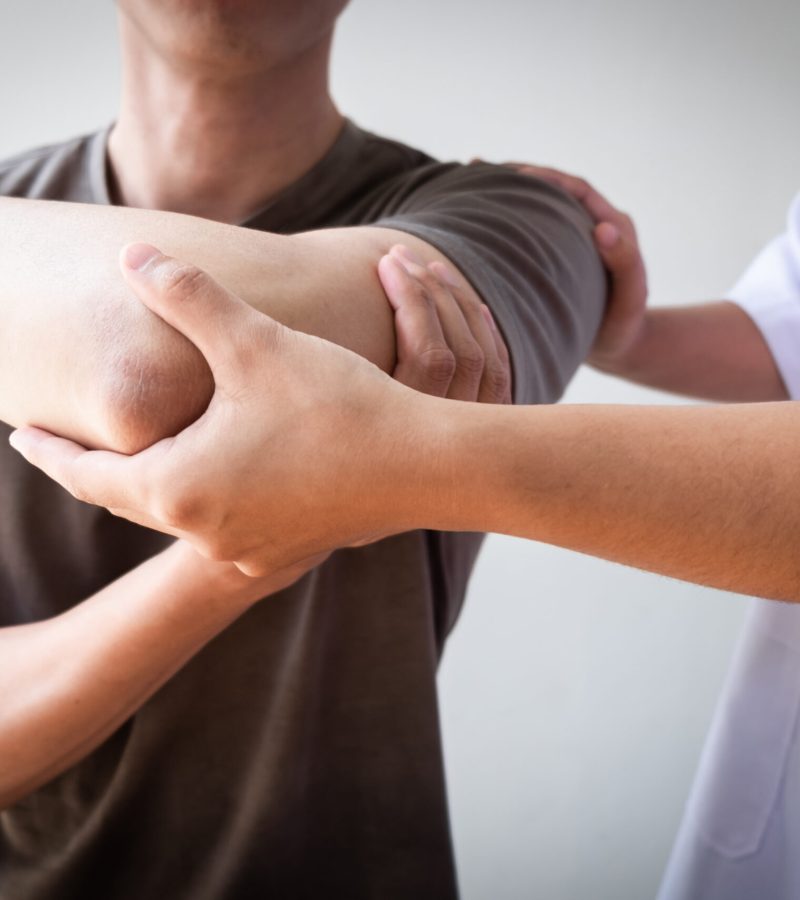 Therapist treating a male injured by rotator cuff stretching method, Physical therapy concept.